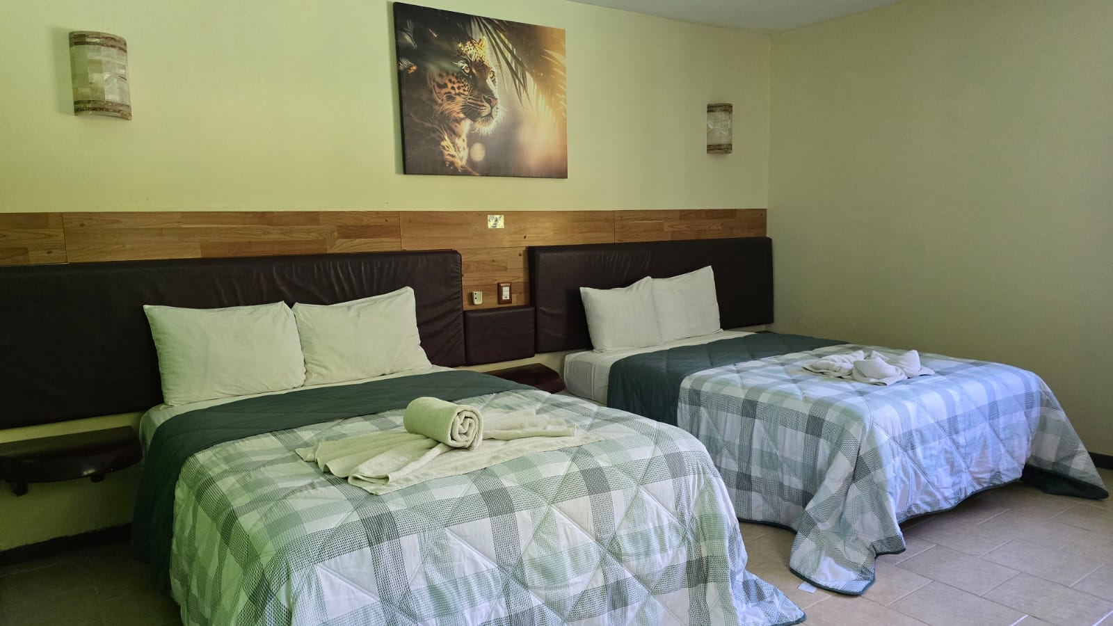 Habitacion con dos camas, ropa blanca y acentos verdes